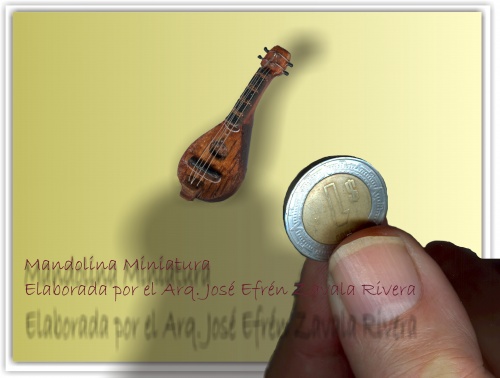 Mandolina pieza musical de madera, para mejor apreciación del tamaño, se compara con la moneda sostenida en los dedos de la mano. - 19 Jan 2009